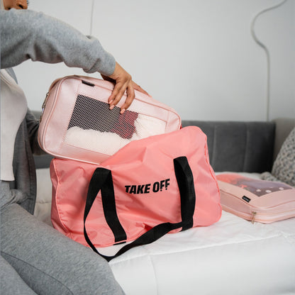A woman places a Take OFF Luggage packing cube inside the Take OFF Duffle Bag 